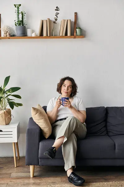 Helle und luftige Räume unterstreichen eine junge Frau, die ihren Kaffee in Komfort und Stil genießt. — Stockfoto