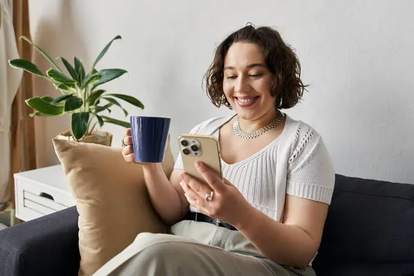 A young woman laughs while checking her phone, surrounded by modern decor and natural light. — Stock Photo