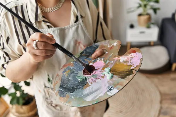Young woman passionately paints in her stylish apartment during the day. — Stock Photo