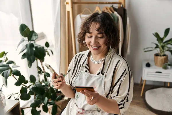 A talented artist joyfully engages with her artwork, surrounded by natural light. — Stock Photo