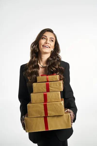 Cheerful lady enjoys carrying stylishly wrapped presents with bright red ribbons. — Stock Photo