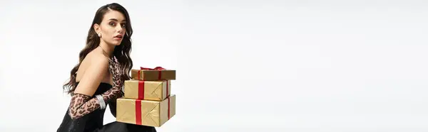 A stylish woman joyfully carries wrapped gifts, eagerly anticipating the celebration. — Stock Photo