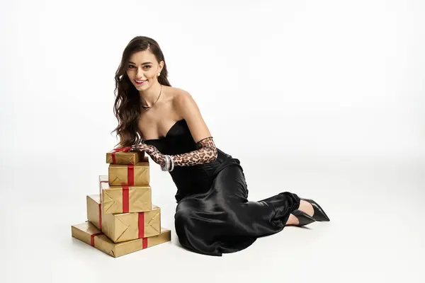 Elegant woman showcases beautifully wrapped gifts while wearing chic gloves and a classic outfit. — Stock Photo