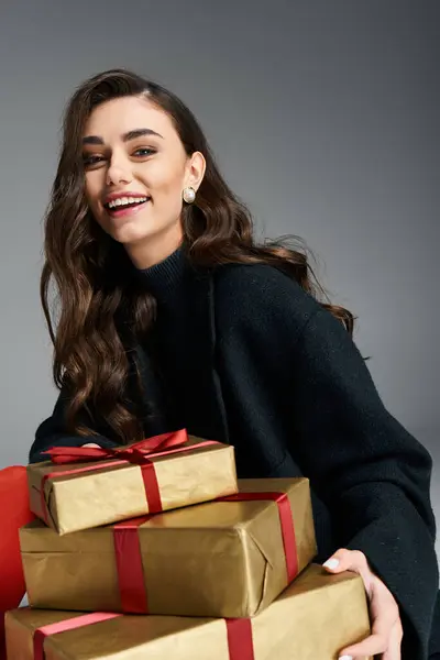 Delighted woman smiles while holding colorful wrapped gifts, embodying festive spirit and joy. — Stock Photo