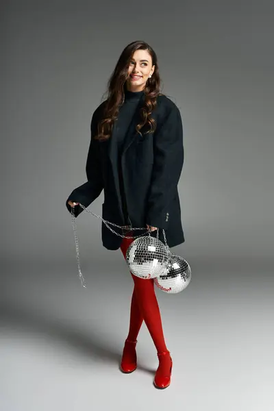 Uma jovem com cabelo comprido se diverte com bolas de discoteca em um espaço criativo. — Fotografia de Stock