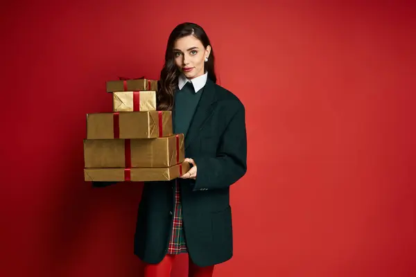 Stylish young woman showcases beautifully wrapped gift boxes in a chic outfit. — Stock Photo