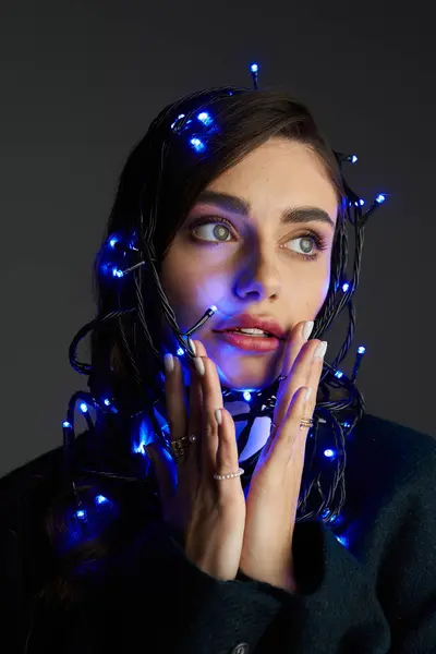 A young woman glows in blue lights, highlighting her expressive features and creative spirit. — Stock Photo