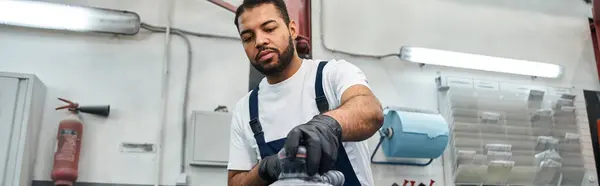 A skilled mechanic focuses on repairing car parts in a well equipped garage environment. — Stock Photo
