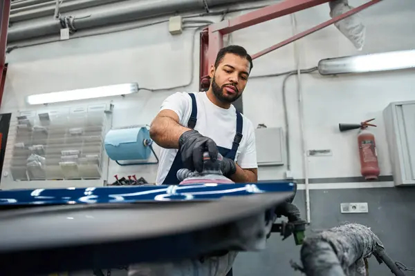 A talented young mechanic works diligently on a vehicle, showcasing expertise and dedication. — Stock Photo