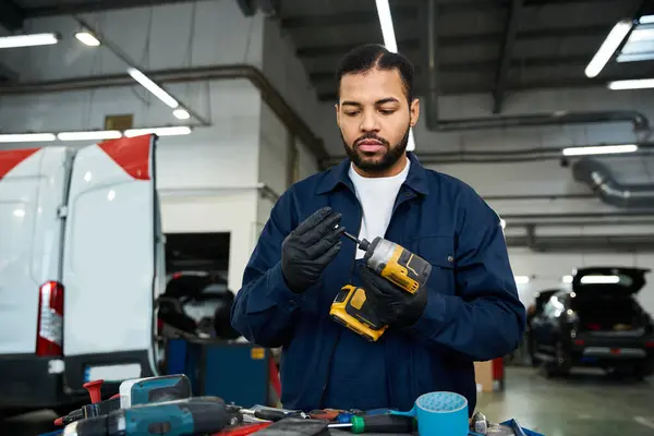 A mechanic inspects equipment surrounded by tools and vehicles in the workshop. — Stock Photo