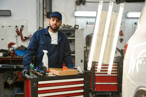 Un meccanico esperto lavora con utensili in un negozio di auto, dimostrando dedizione e competenza. — Foto stock