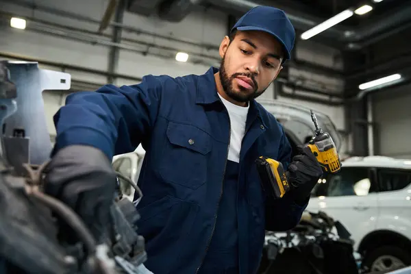 Junge Mechaniker beschäftigen sich intensiv mit der Reparatur eines Fahrzeugmotors mit fachkundigem Werkzeug und Präzision. — Stockfoto