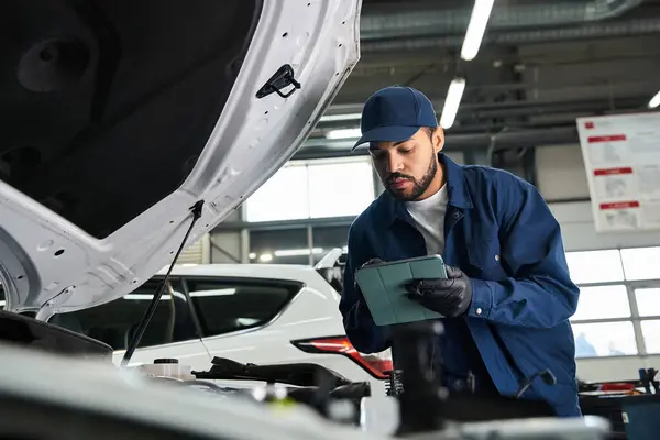 Junger Mechaniker überprüft Fahrzeugdiagnose in der Werkstatt. — Stockfoto