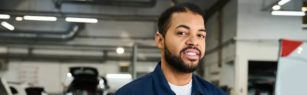 Joven mecánico experto se involucra con los clientes en un ambiente de reparación de automóviles brillante y ocupado. — Stock Photo