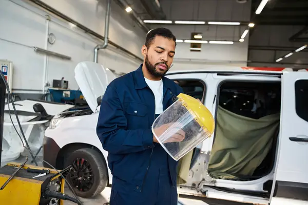 Skilled mechanic inspects safety gear while working in a vibrant auto repair facility — Stock Photo