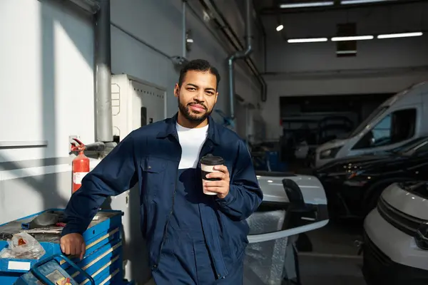 Meccanico fiducioso si rilassa con il caffè durante una giornata lavorativa intensa in garage. — Foto stock