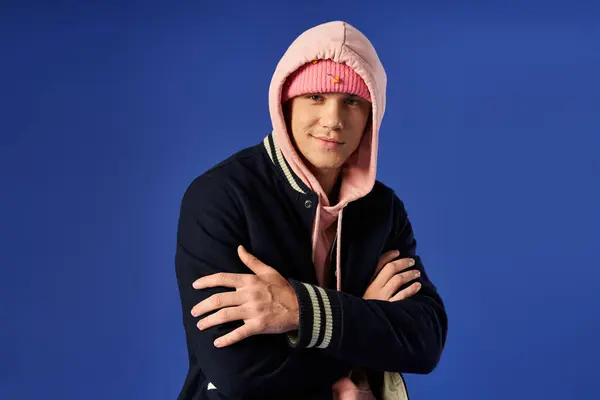 Young man wears a pink hoodie and black jacket, showing confidence. — Stock Photo