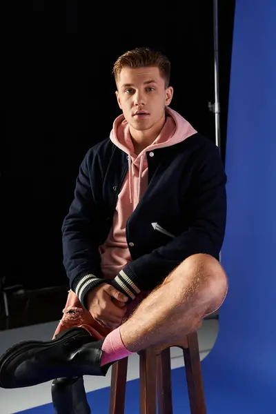 Confident young man in stylish casual wear sits on a stool with a prosthetic leg. — Stock Photo