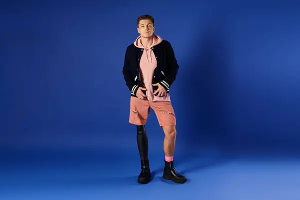 Joven confiado con una pierna protésica muestra su atuendo elegante y energía positiva. - foto de stock
