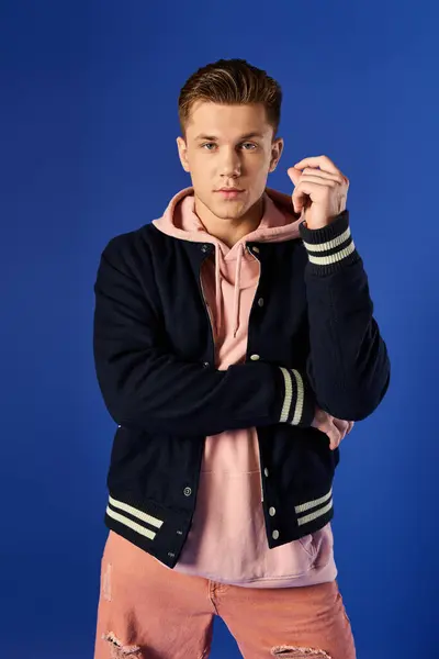Young man shows confidence in modern fashion against a bright backdrop. — Stock Photo