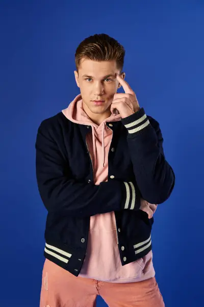 Ein stilvoller junger Mann steht selbstbewusst in lässiger Kleidung. — Stockfoto