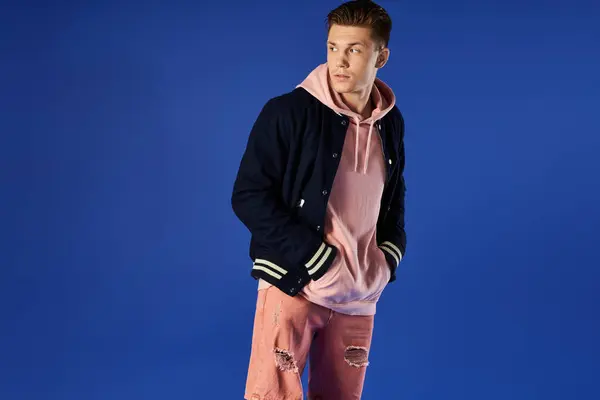 Young man showcases his style, wearing casual clothing in a vibrant setting. — Stock Photo