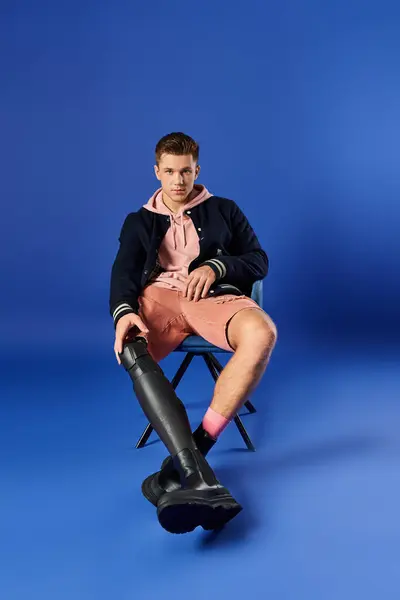 Joven con confianza posa con estilo mientras está sentado con su pierna protésica. — Stock Photo