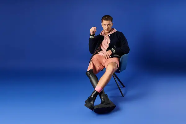 Young man with prosthetic leg showcases modern fashion while sitting comfortably on a chair. — Stock Photo