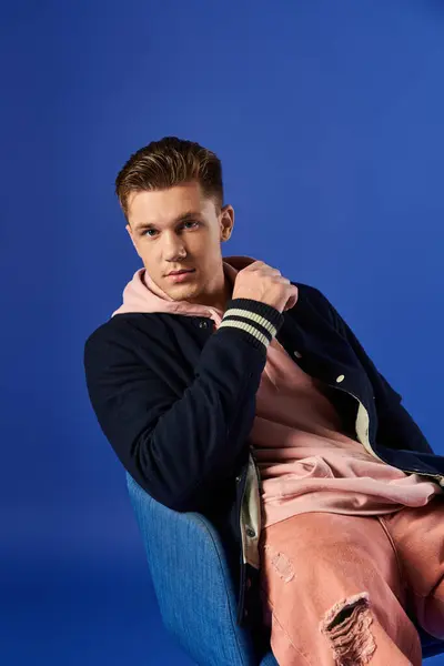 Young man rests in a chair, showcasing his fashion sense and relaxed demeanor. — Stock Photo