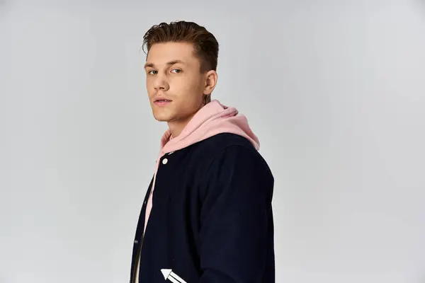 Young man stands confidently, showcasing a modern and stylish outfit. — Stock Photo
