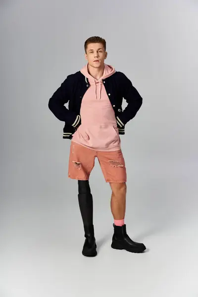 Young man in casual wear confidently showcases his prosthetic leg, embodying resilience. — Stock Photo