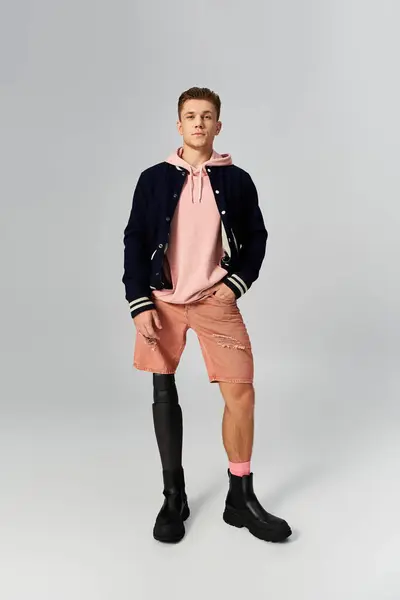 Young man in stylish casual wear stands tall with a prosthetic leg, radiating confidence. — Stock Photo