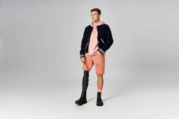 Young man stands tall, wearing a stylish outfit and proudly displaying his prosthetic leg. — Stock Photo