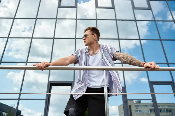 A young man with a prosthetic leg stands on a balcony enjoying the view and sunlight. — Stock Photo
