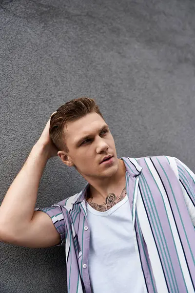 Young man poses confidently, expressing a stylish demeanor and uniqueness. — Stock Photo