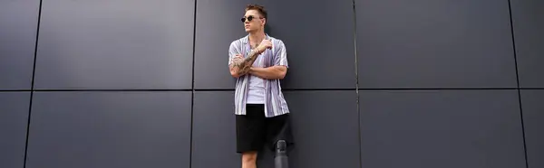 Handsome young man with a prosthetic leg leans against a stylish wall, exuding confidence. — Stock Photo