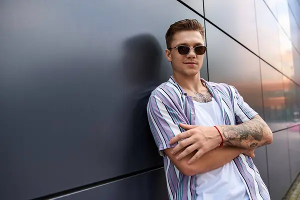 Young man with tattoos stands in a casual pose, showing confidence and style. — Stock Photo