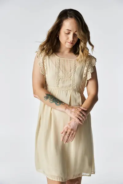 A young woman with vitiligo stands thoughtfully, showcasing her unique beauty in a soft dress. — Stock Photo