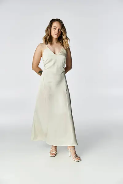 A young woman with vitiligo confidently showcases her beauty in a sleek dress in the studio. — Stock Photo