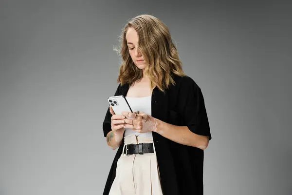 A young woman with vitiligo stands confidently while using her phone, showcasing her beauty. — Stock Photo