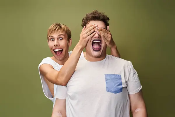 Two friends share a moment of laughter as one playfully covers the others eyes with excitement. — Stock Photo