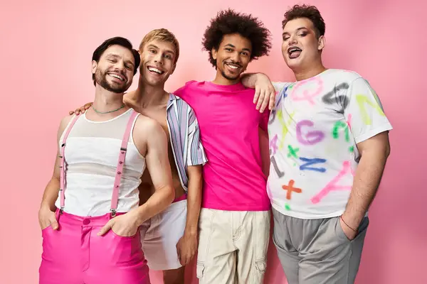 Four friends in bright outfits express joy and pride against a pink backdrop. — Stock Photo