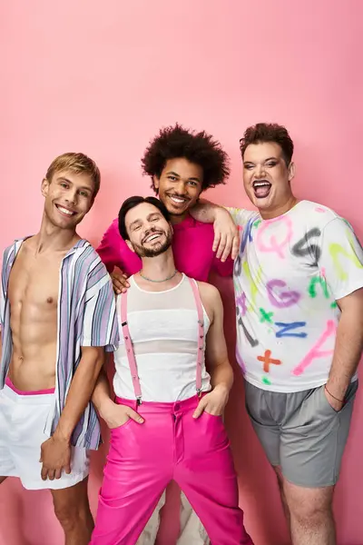 Quattro amici posano insieme in abiti vivaci, trasudando gioia e fiducia in uno sfondo rosa. — Foto stock