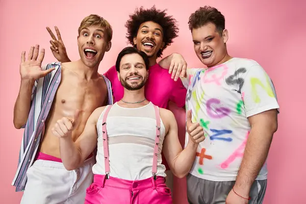 Four friends express joy and pride with colorful outfits against a pink backdrop. — Stock Photo