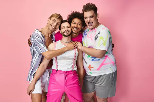 Four friends embrace joyfully against a pink backdrop, celebrating their queer identity and pride. — Stock Photo