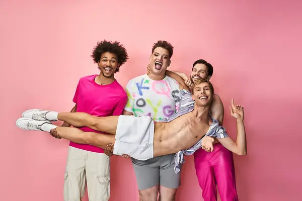 Group of friends exuding joy and pride with vibrant outfits against a pink backdrop. — Stock Photo