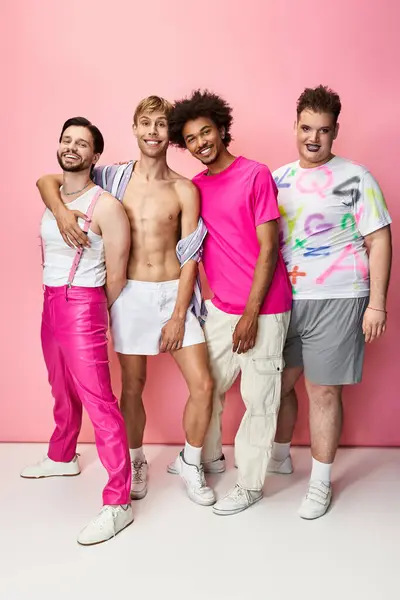 Four queer individuals celebrate pride in a studio, showcasing their vibrant outfits. — Stock Photo