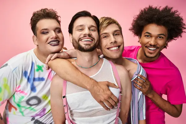Four friends share joy and pride, showcasing vibrant outfits and smiles in a colorful setting. — Stock Photo