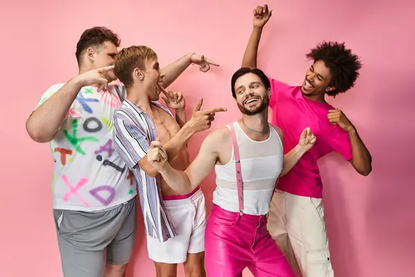 Four friends joyfully celebrate their identities while posing against a vivid pink backdrop. — Stock Photo
