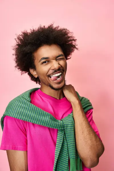 Person with a lively expression showcases pride and vibrancy against a bright pink background. — Stock Photo